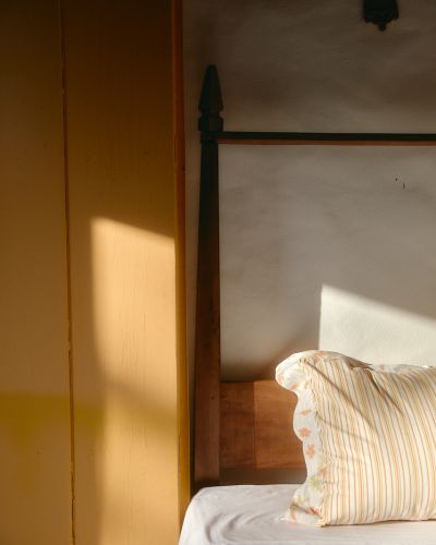 Sunlight on wooden furniture next to a bed